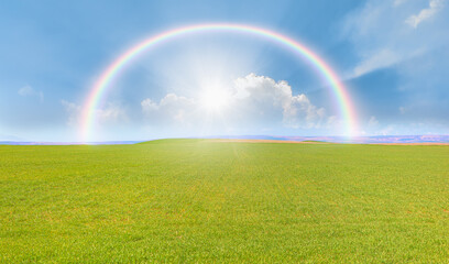 Beautiful landscape with green grass field amazing rainbow in the background 