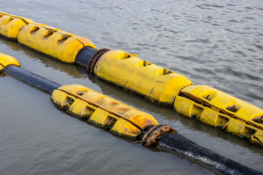Floating old dredging pipes on the river close up
