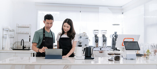 Startup successful small business owner sme boy girl stand with tablet in coffee shop restaurant. Portrait of asian tan man woman barista cafe owner. SME entrepreneur seller business delivery concept