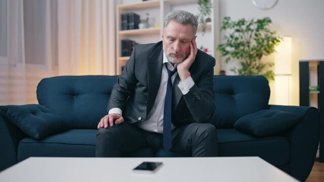Sad middle-aged man looking at smartphone, waiting for call, failed expectations