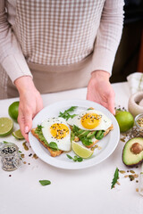 Obraz na płótnie Canvas healthy breakfast or snack - sliced avocado and fried egg on toasted bread 