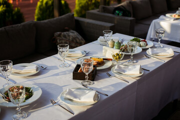 festive table with glasses and plates on a white tablecloth