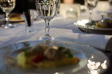 festive table with glasses and plates on a white tablecloth