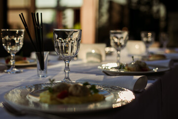 festive table with glasses and plates on a white tablecloth