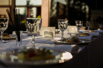 festive table with glasses and plates on a white tablecloth