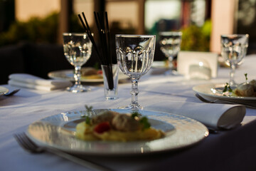 festive table with glasses and plates on a white tablecloth
