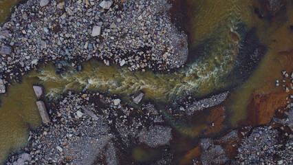 Swamp river flows along the stones