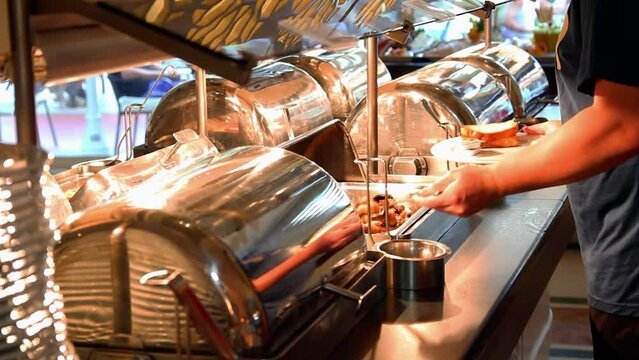 Self Service Catering Buffet - Man Choosing Food From Warming Trays At Restaurant Buffet. Self-Service Restaurant In An Elegant Hotel Dining Room. 