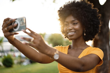 Portrait of a young afro american woman taking a selfie outdoor