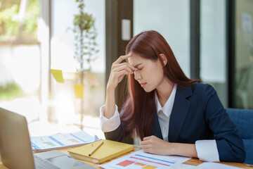 Portrait of an Asian businesswoman showing a headache from depression