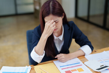 Portrait of an Asian businesswoman showing a headache from depression