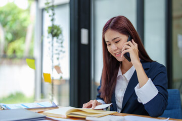 Asian businesswoman using the phone to contact a business partner