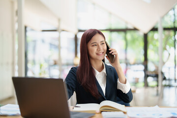 Asian businesswoman using the phone to contact a business partner