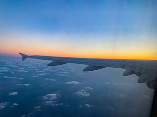 Fototapeta premium airplane in the sky, view from airplane, flying and traveling, view from airplane window on the wing on sunset time