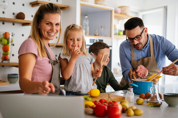 Happy family preparing healthy food together in kitchen