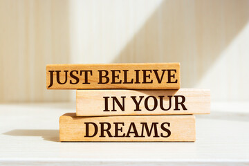 Wooden blocks with words 'Just believe in your dreams'.