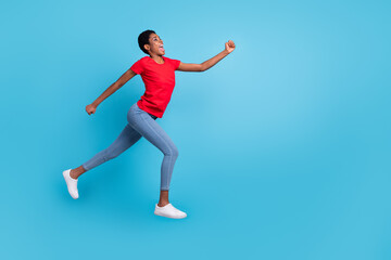 Fototapeta na wymiar Full size photo of sportive energetic person jump rush look empty space isolated on blue color background