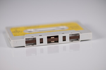 Music cassette with yellow label lying on a light background