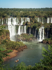 Tourist boat exploring Iguazu Falls on the border of Brazil and Argentina. - obrazy, fototapety, plakaty