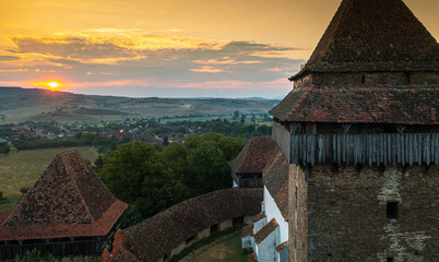 Aerial view with Viscri fortified church from Transylvania, Romania, during a beautiful summer sunrise. Travel to landmarks of Romania.