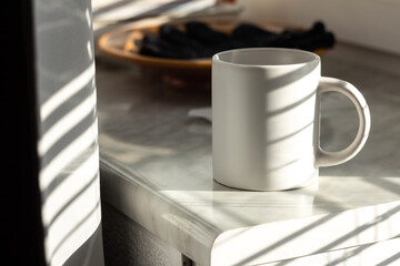 A white mug on the windowsill - 520752161