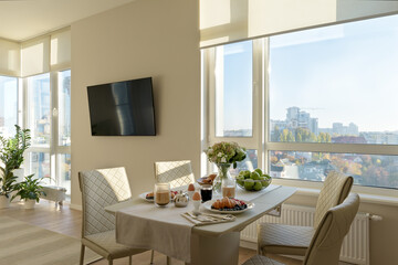 modern dining room with table, modern living room with light walls, breakfast in the apartment