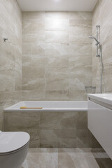 modern bathroom interior, bathroom with beige tile with stone texture