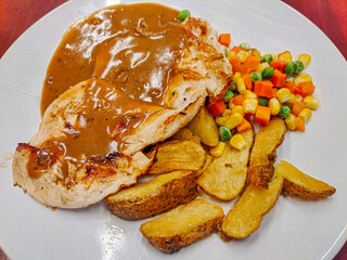 Chicken Steak with mushroom sauce ,vegetables and potato wedges