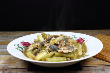Traditional fried fresh lotus stem mixed with mackerel fish serving on the plate. Famous luxury seafood menu in Asia restaurant.