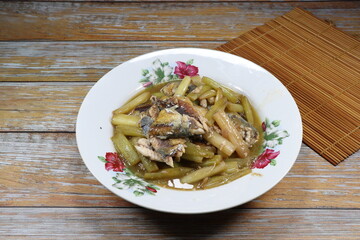 Traditional fried fresh lotus stem mixed with mackerel fish serving on the plate. Famous luxury seafood menu in Asia restaurant.