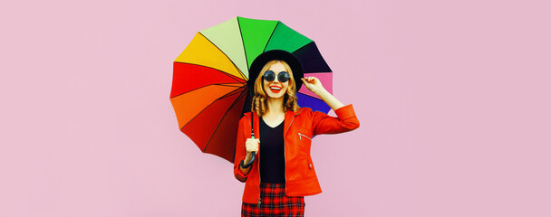 Autumn portrait of happy smiling young woman holding colorful umbrella wearing jacket on background