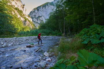 Woman hiker crossing river