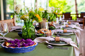 beautiful setting of a large table with flowers. 