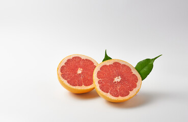 Grapefruit halves on white background with leaves. The concept is vitamin C.