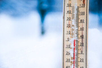 Winter time. thermometer on snow shows low temperatures in celsius or fahreneheit.