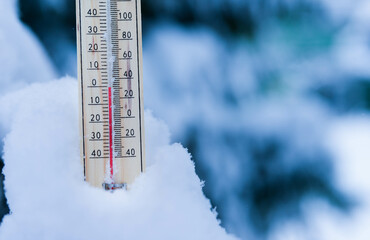 Winter time. thermometer on snow shows low temperatures in celsius or fahreneheit.
