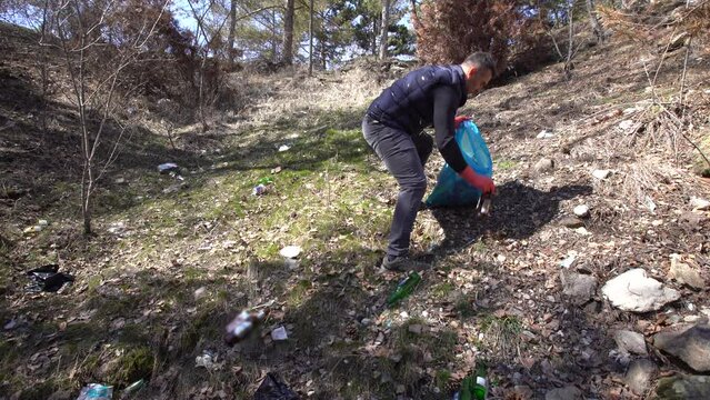 Environmental pollution, garbage in nature.
Plastic, paper and glass garbage thrown into the forest, universal waste. Environmentally friendly people collect garbage.
