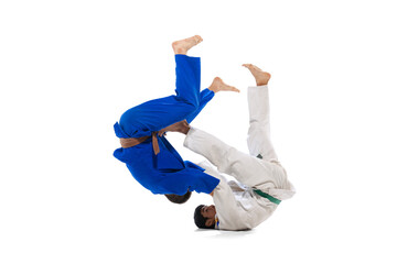 Studio shot of two men, professional judo athletes training isolated over white background