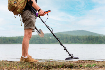 metal detector at work in the forest or field. Search for treasure and ancient values. Archeology....