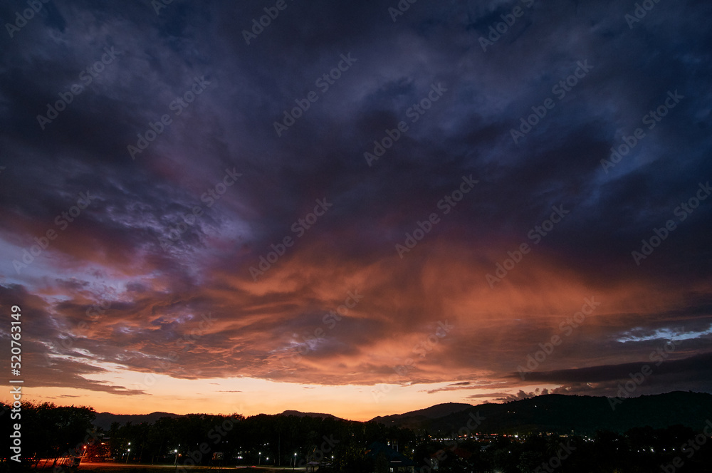 Wall mural dramatic landscape with view on evening city. beautiful cloudy sky.