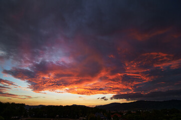 Dramatic landscape with view on evening city. Beautiful cloudy sky.