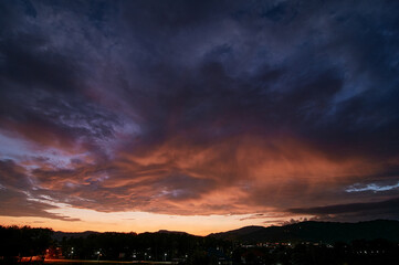 Fototapeta premium Dramatic landscape with view on evening city. Beautiful cloudy sky.