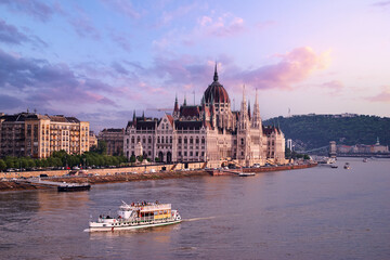 Obraz premium The Hungarian Parliament Building on the bank of the Danube in Budapest at sunset time.