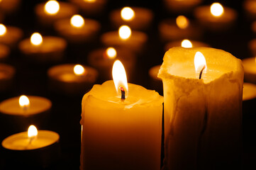 Two burning candles in the dark