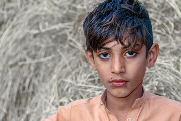 Homeless cute boy in white Asian clothes young child with a sad face