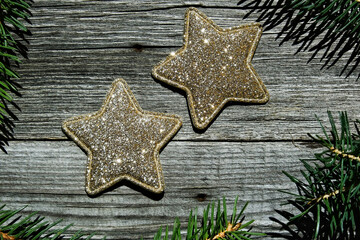 Golden sparkling stars on a wooden background. Flat lay.