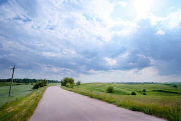 Open straight road in green field.