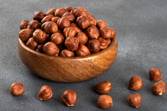 Top view of a bowl full of hazelnuts  on dark background