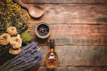 Fototapeta na wymiar Herbal medicine concept background. Dry natural ingredients and remedy bottle on the wooden table background with copy space. Top view.