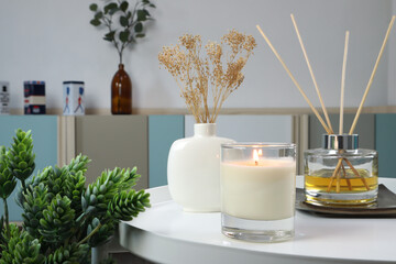 luxury lighting aromatic scented candle is on white metal table with ceramic vase and reed diffuser...